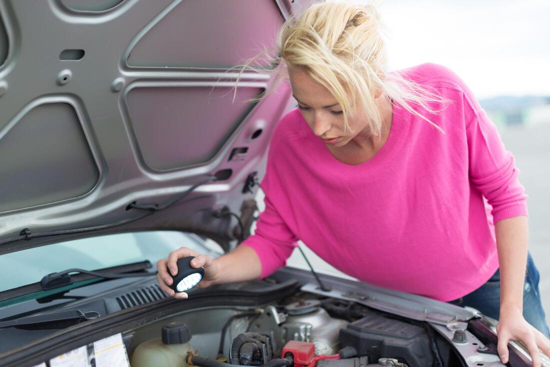 woman ispecting car engine