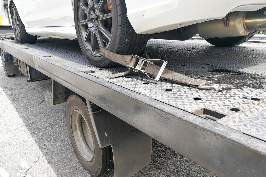 car towed by flatbed truck
